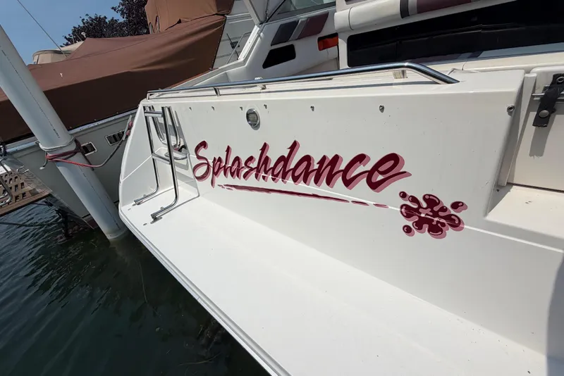Slide: The Image of 1989 Sea Ray Sundancer 280 boat with "Splashdance" name on the stern, docked in water. - 8