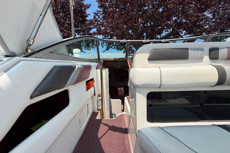 Slide: The Image of 1989 Sea Ray Sundancer 280 interior with white and gray seating, open cabin entrance. - 15