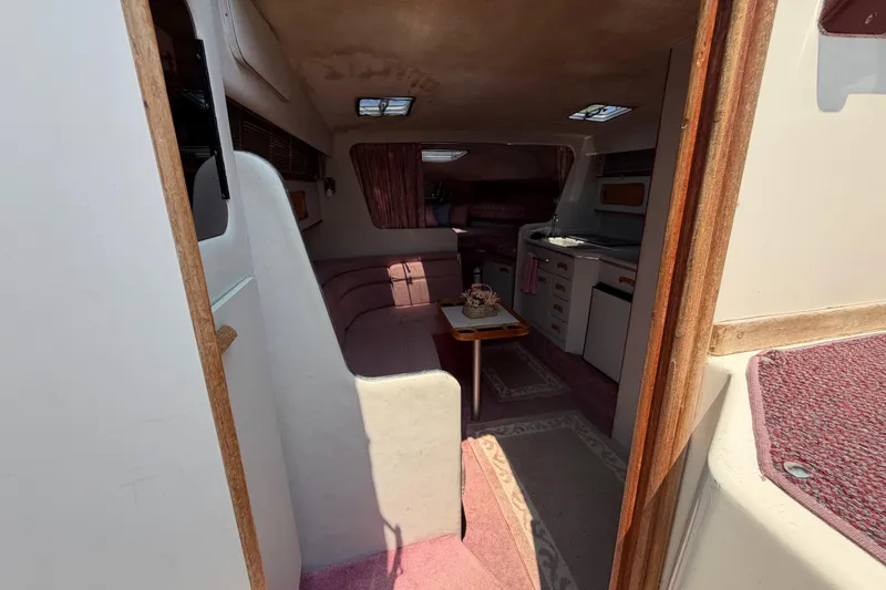Slide: The Image of Interior of 1989 Sea Ray Sundancer 280 boat, featuring cozy seating and kitchenette. - 21