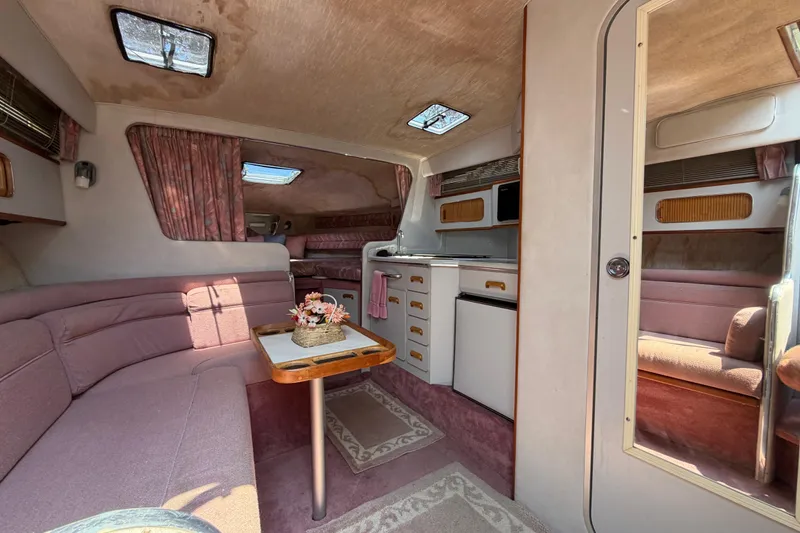Slide: The Image of Interior of a 1989 Sea Ray Sundancer 280 boat with cozy seating and kitchenette. - 22