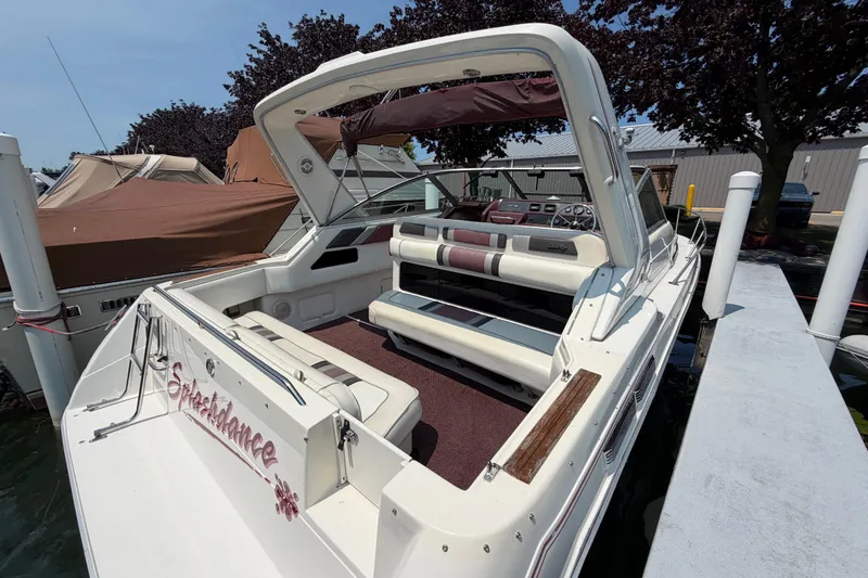 Slide: The Image of 1989 Sea Ray Sundancer 280 boat docked, featuring spacious seating and classic design. - 10
