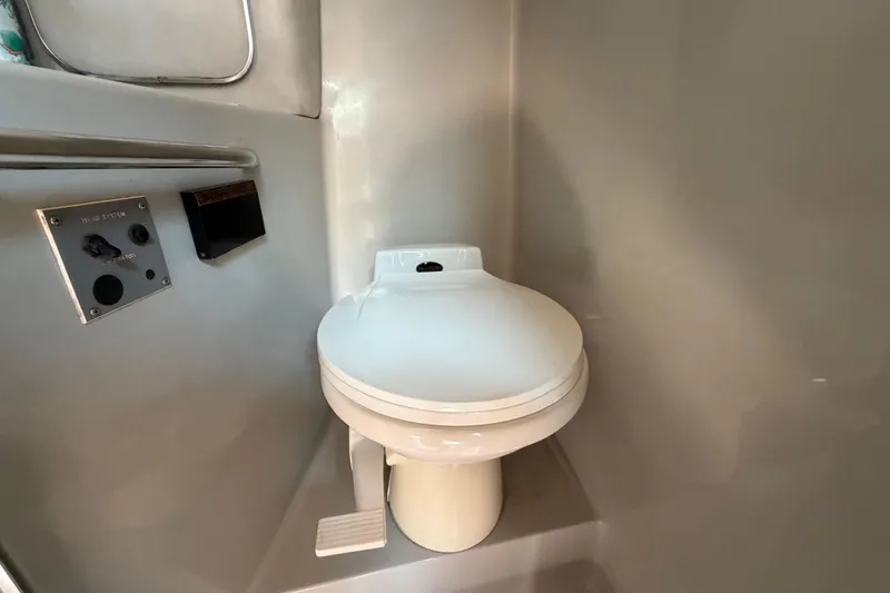 Slide: The Image of 1989 Sea Ray Sundancer 280 boat bathroom with toilet and control panel. - 36