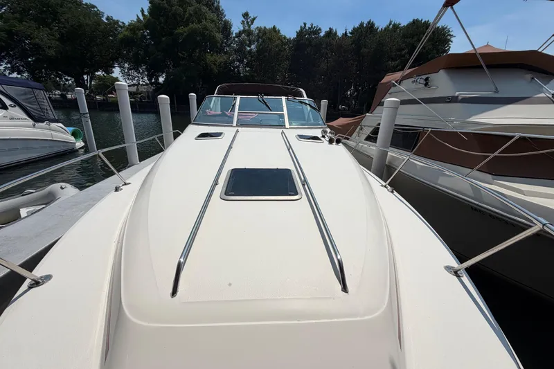 Slide: The Image of 1989 Sea Ray Sundancer 280 docked, showcasing sleek deck design and surrounding boats. - 4