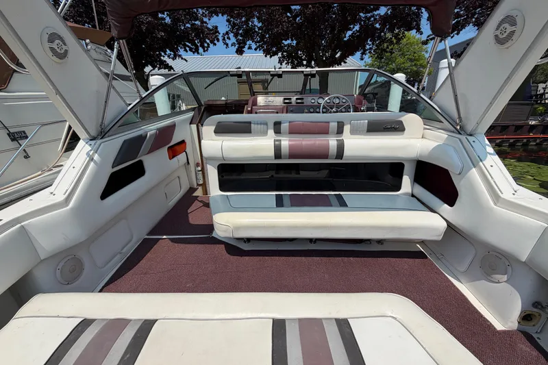 Slide: The Image of 1989 Sea Ray Sundancer 280 interior with white and maroon seating, open cockpit view. - 11