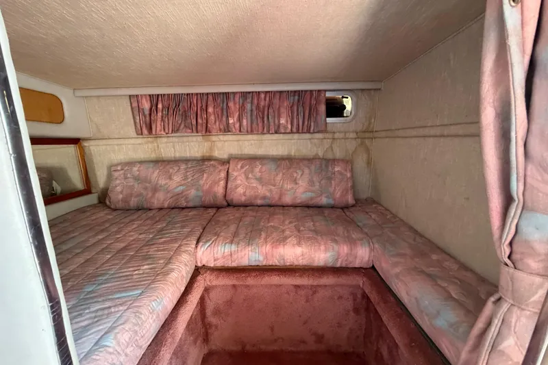 Slide: The Image of Interior cabin of 1989 Sea Ray Sundancer 280 with pink upholstery and curtains. - 31