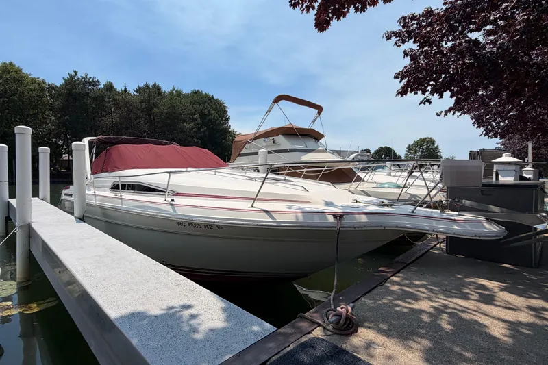 Slide: The Image of 1989 Sea Ray Sundancer 280 docked at marina, surrounded by trees and boats. - 43