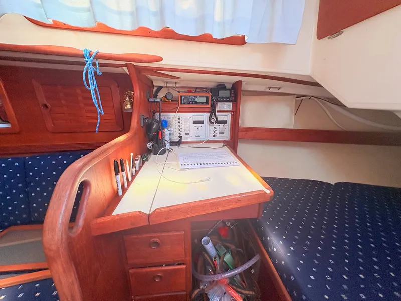 Slide: The Image of The interior of a 1987 Sabre 30 MK III features a navigation area with wooden furnishings and blue upholstery. - 26