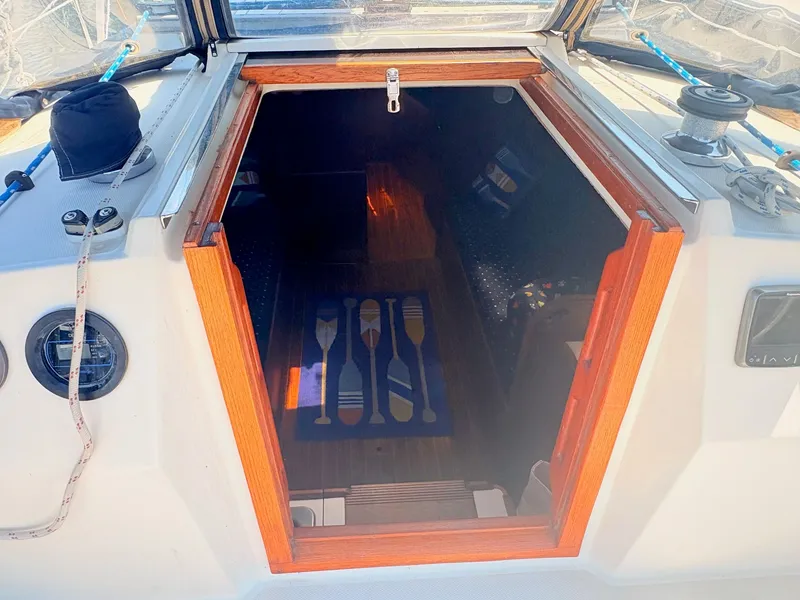 Slide: The Image of The image shows the cabin entrance of a sailboat with wooden doors and a blue rug. - 10