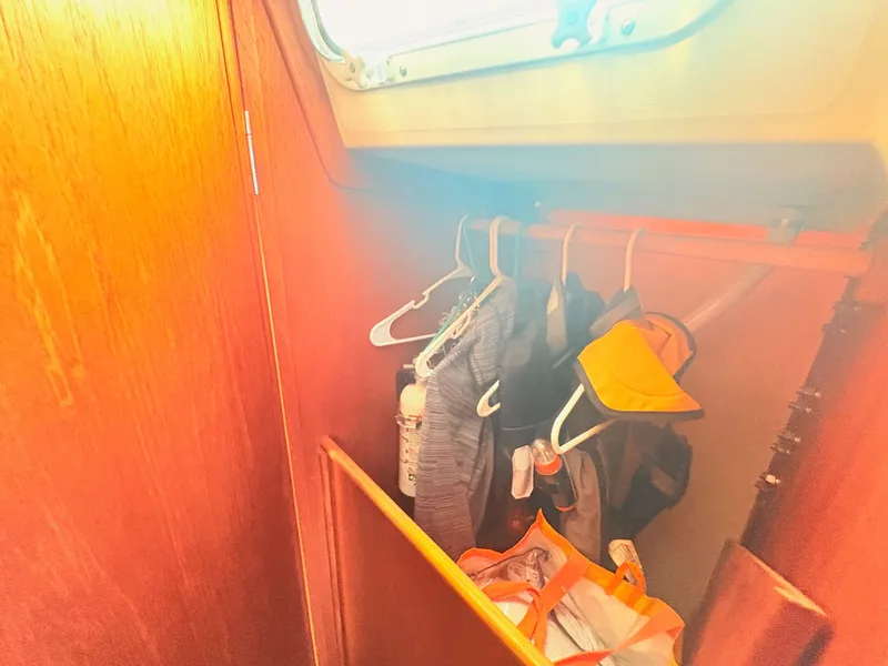 Slide: The Image of A closet inside a 1987 Sabre 30 MK III boat with clothes and bags. - 20