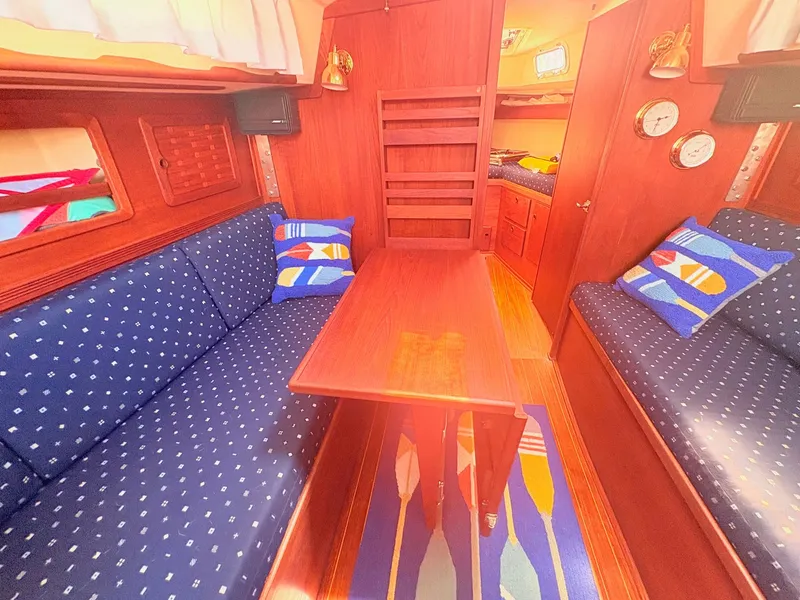 Slide: The Image of Interior of a 1987 Sabre 30 MK III with wooden table, blue upholstery, and colorful cushions. - 17