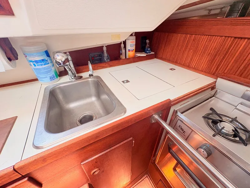 Slide: The Image of The galley of a 1987 Sabre 30 MK III with a sink, stove, and wood paneling. - 30