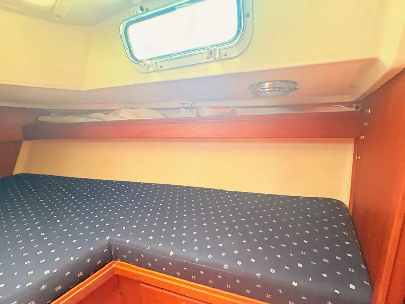 Slide: The Image of The cabin of a 1987 Sabre 30 MK III with a cushioned bed and a porthole. - 23