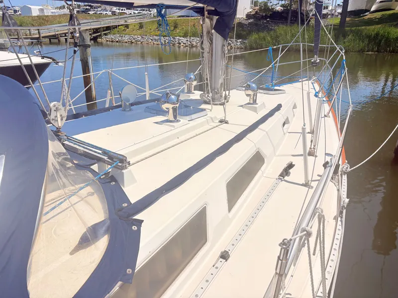 Slide: The Image of The image shows a sailboat docked, featuring a clean deck and blue covers. - 4