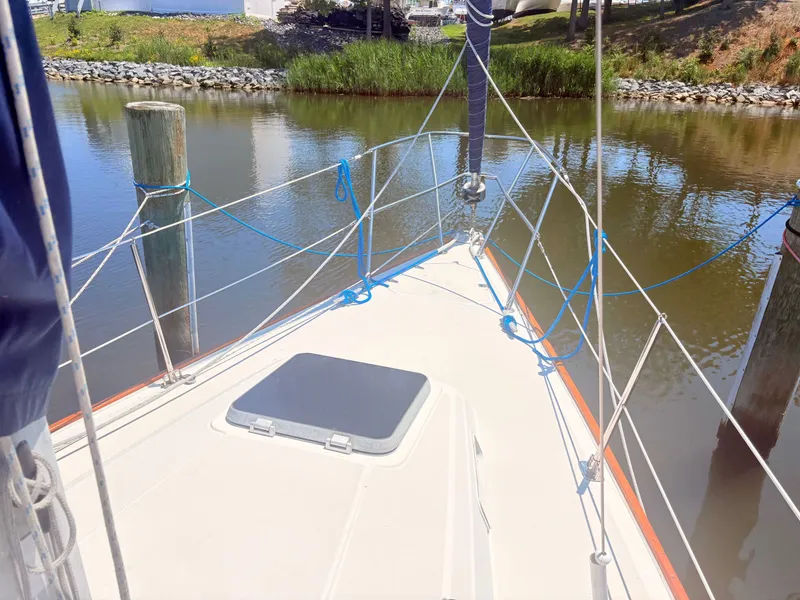 Slide: The Image of The deck of a sailboat with blue ropes and a small hatch. - 5