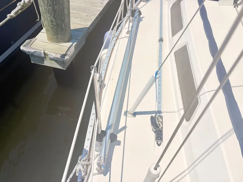 Slide: The Image of The image shows the deck of a sailboat next to a wooden dock. - 7