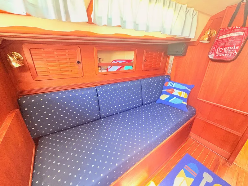 Slide: The Image of The cabin of the 1987 Sabre 30 MK III features a cushioned bench with blue pillows. - 13