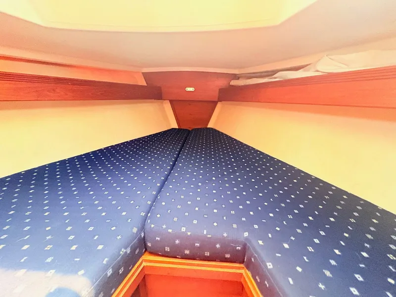 Slide: The Image of The cabin of the 1987 Sabre 30 MK III features a V-shaped bed with blue upholstery. - 22