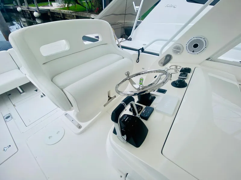 Slide: The Image of 2008 Intrepid 390 Sport Yacht helm station with white seating and control panel. - 34