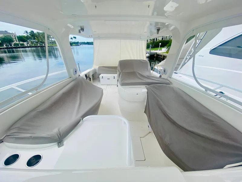 Slide: The Image of 2008 Intrepid 390 Sport Yacht interior with covered seating, docked by a serene waterfront. - 20