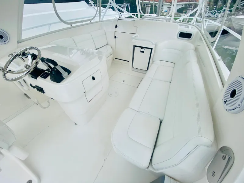 Slide: The Image of 2008 Intrepid 390 Sport Yacht interior with white seating and helm station. - 28