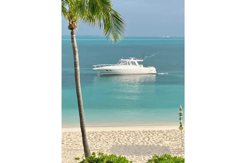 Slide: The Image of A 2008 Intrepid 390 Sport Yacht anchored in turquoise waters near a sandy beach. - 2