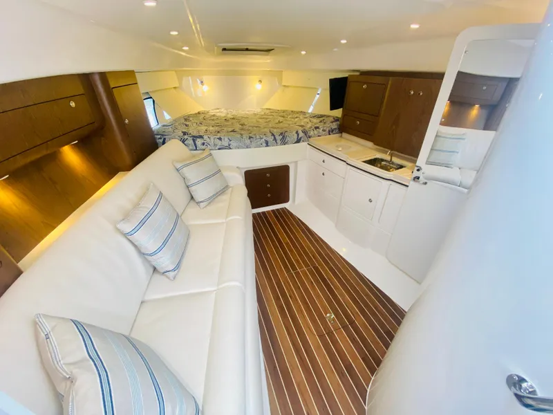 Slide: The Image of Interior of 2008 Intrepid 390 Sport Yacht with white leather seating and wood accents. - 52