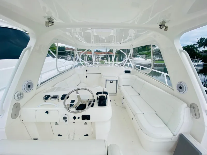 Slide: The Image of 2008 Intrepid 390 Sport Yacht cockpit with white seating and steering console. - 24