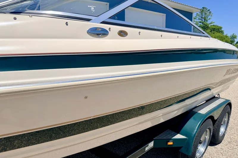 Slide: The Image of 2002 Larson LXi 210 boat on trailer, beige and green exterior, sunny day. - 12