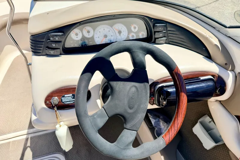 Slide: The Image of 2002 Larson LXi 210 boat dashboard with steering wheel and instrument panel. - 32