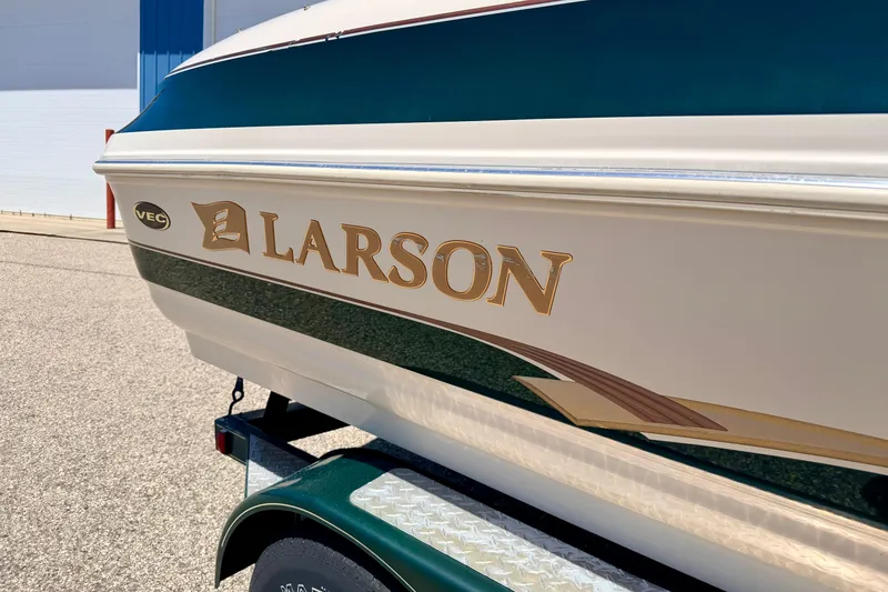 Slide: The Image of 2002 Larson LXi 210 boat side view with logo and trailer. - 9