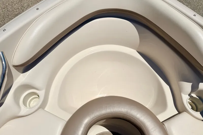 Slide: The Image of Interior of a 2002 Larson LXi 210 boat, featuring beige seating and cup holders. - 53