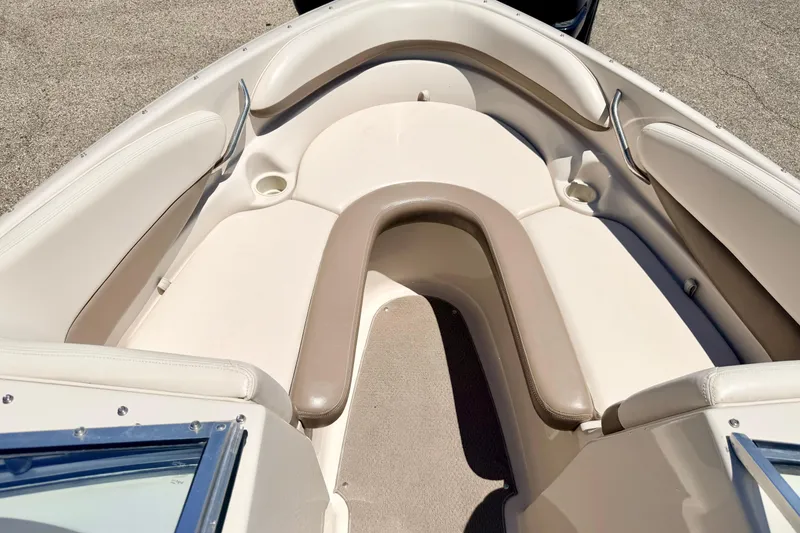 Slide: The Image of 2002 Larson LXi 210 boat interior with beige seating and cup holders. - 49