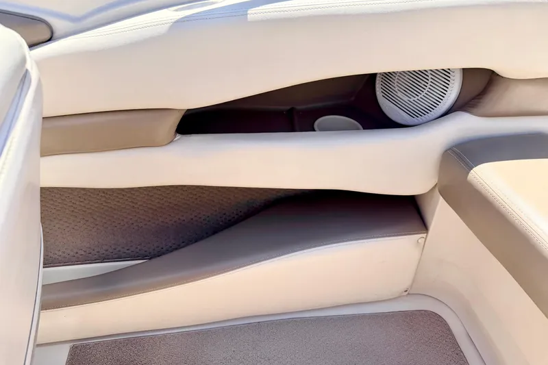 Slide: The Image of Interior of a 2002 Larson LXi 210 boat, featuring beige upholstery and speaker system. - 47