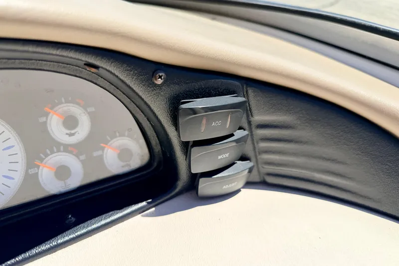 Slide: The Image of Dashboard controls of a 2002 Larson LXi 210 boat with gauges and buttons. - 35