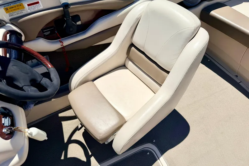 Slide: The Image of 2002 Larson LXi 210 boat interior with beige captain's seat and steering wheel. - 41