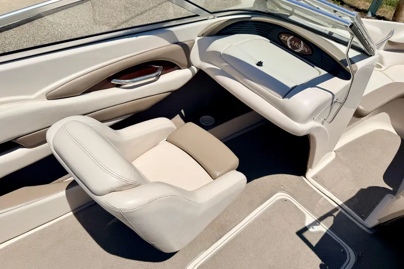 Slide: The Image of Interior of a 2002 Larson LXi 210 boat, featuring beige seating and dashboard. - 43
