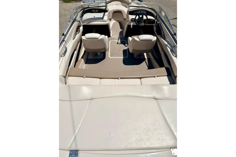 Slide: The Image of Interior view of a 2002 Larson LXi 210 boat with beige seating and steering wheel. - 22