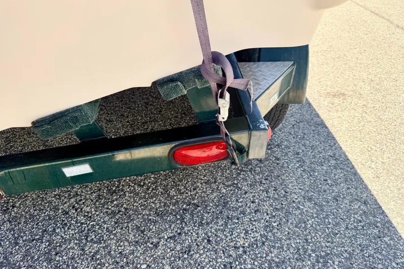 Slide: The Image of Trailer hitch of a 2002 Larson LXi 210 boat on asphalt surface. - 68