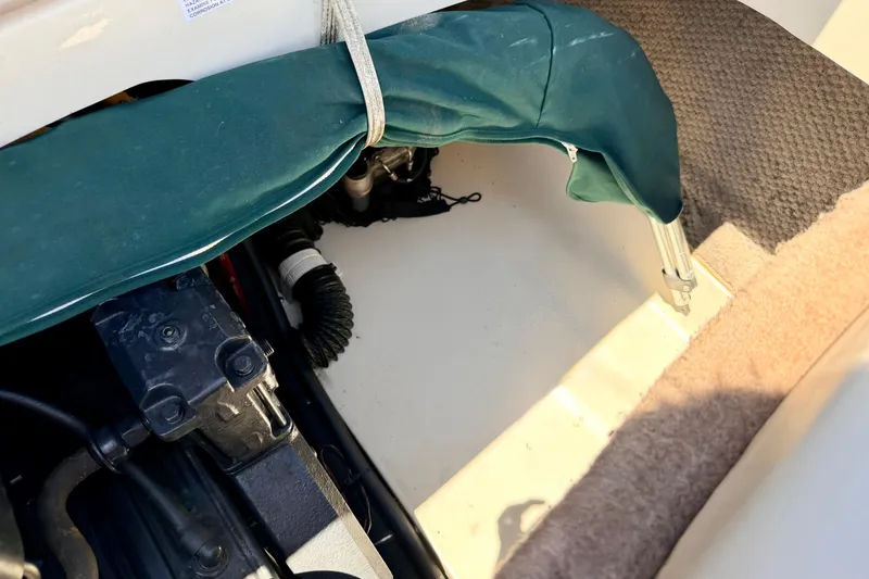Slide: The Image of Engine compartment of a 2002 Larson LXi 210 boat with green cover and carpeted flooring. - 26