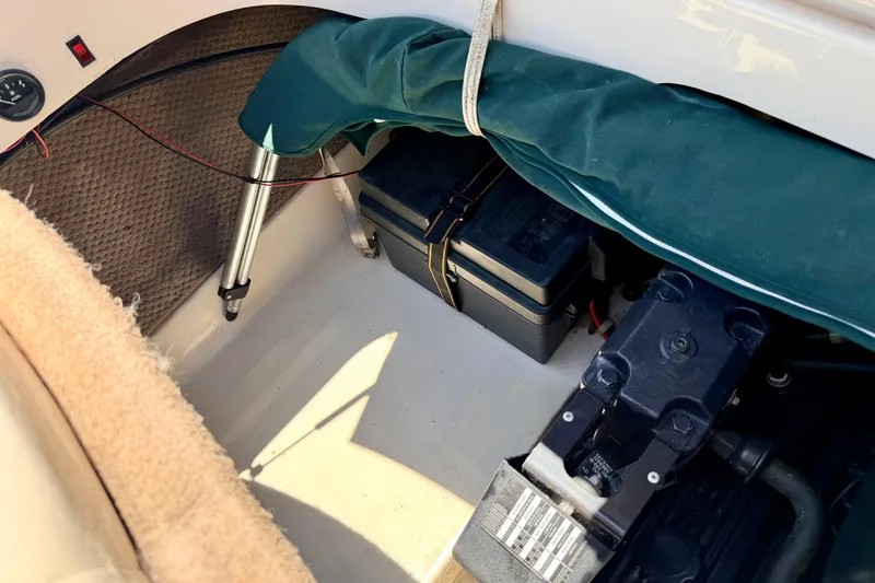 Slide: The Image of Interior view of a 2002 Larson LXi 210 boat showing storage and battery compartment. - 25