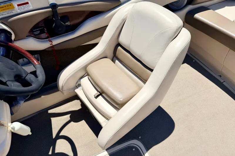 Slide: The Image of Beige captain's chair in 2002 Larson LXi 210 boat interior, near steering wheel. - 42