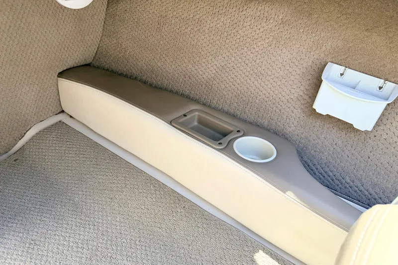 Slide: The Image of Interior of a 2002 Larson LXi 210 boat showing beige upholstery and cup holder. - 40