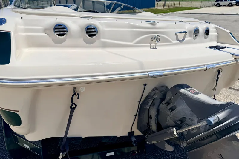 Slide: The Image of 2002 Larson LXi 210 boat stern with outboard motor, parked on a sunny day. - 17
