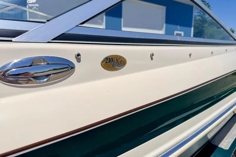 Slide: The Image of 2002 Larson LXi 210 boat side view with emblem and chrome handle. - 13