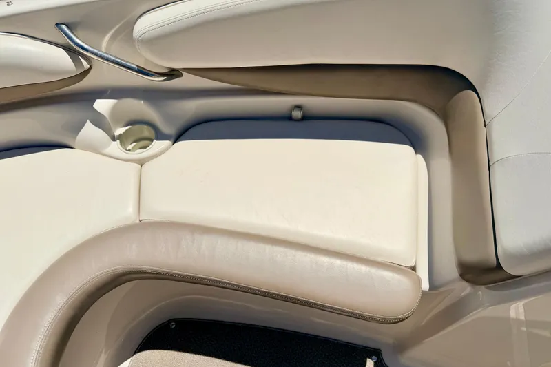 Slide: The Image of 2002 Larson LXi 210 boat interior with beige seating and cup holder. - 54