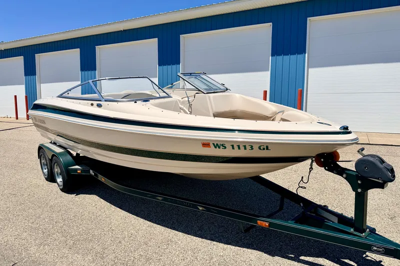 Slide: The Image of 2002 Larson LXi 210 boat on trailer, parked outside blue storage facility. - 5