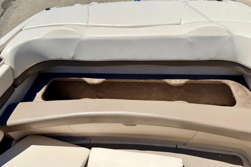 Slide: The Image of 2002 Larson LXi 210 boat interior with open storage compartment, beige upholstery. - 29