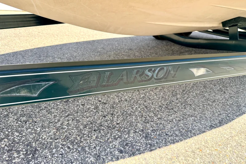 Slide: The Image of Close-up of 2002 Larson LXi 210 boat trailer branding on pavement. - 63