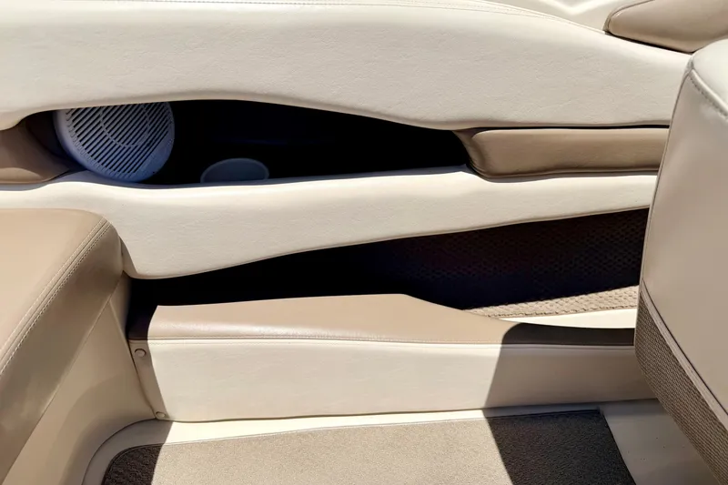 Slide: The Image of Interior of a 2002 Larson LXi 210 boat, featuring beige and tan upholstery. - 48