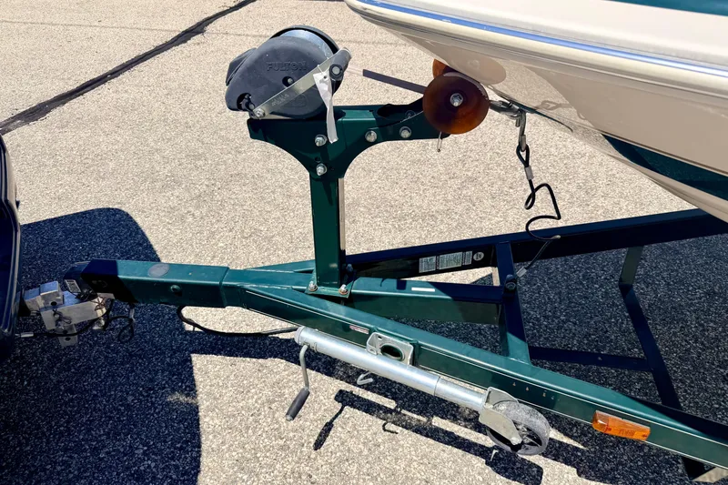Slide: The Image of Trailer hitch of a 2002 Larson LXi 210 boat on pavement. - 62